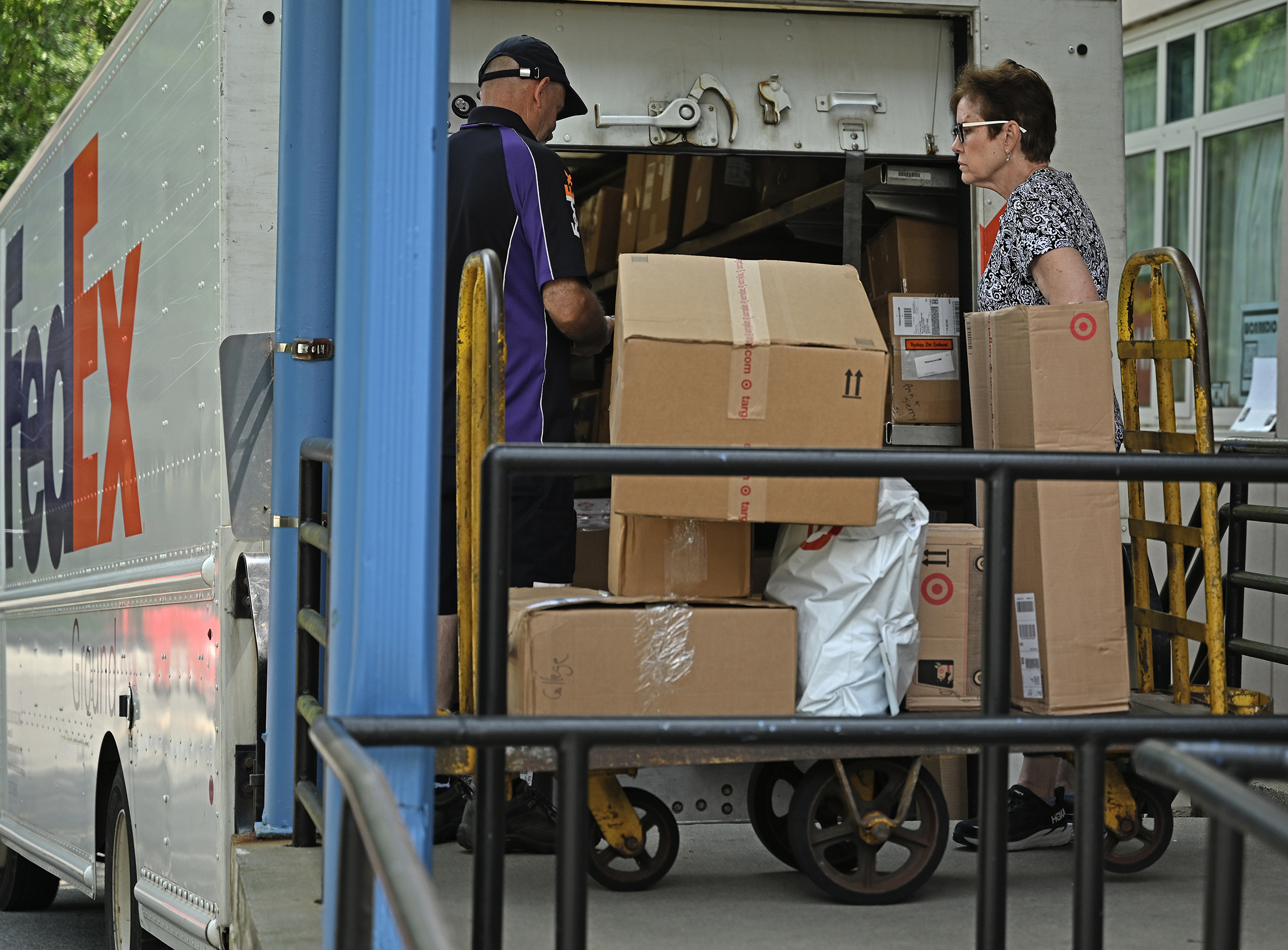 A post office employee gathers packages being delivered to a loading dock