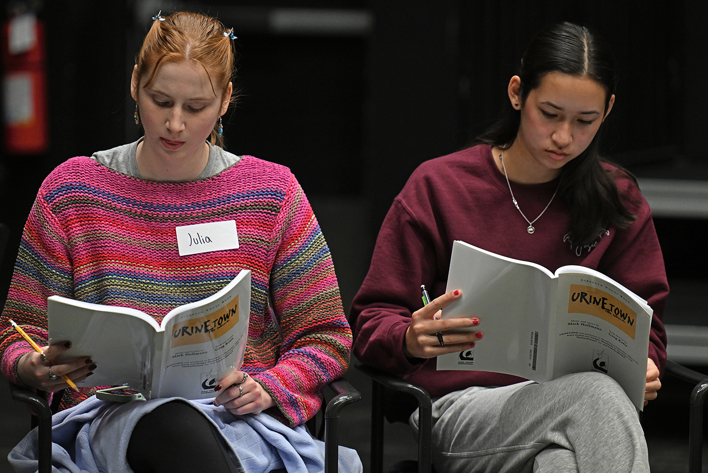 two student actors read their script books.