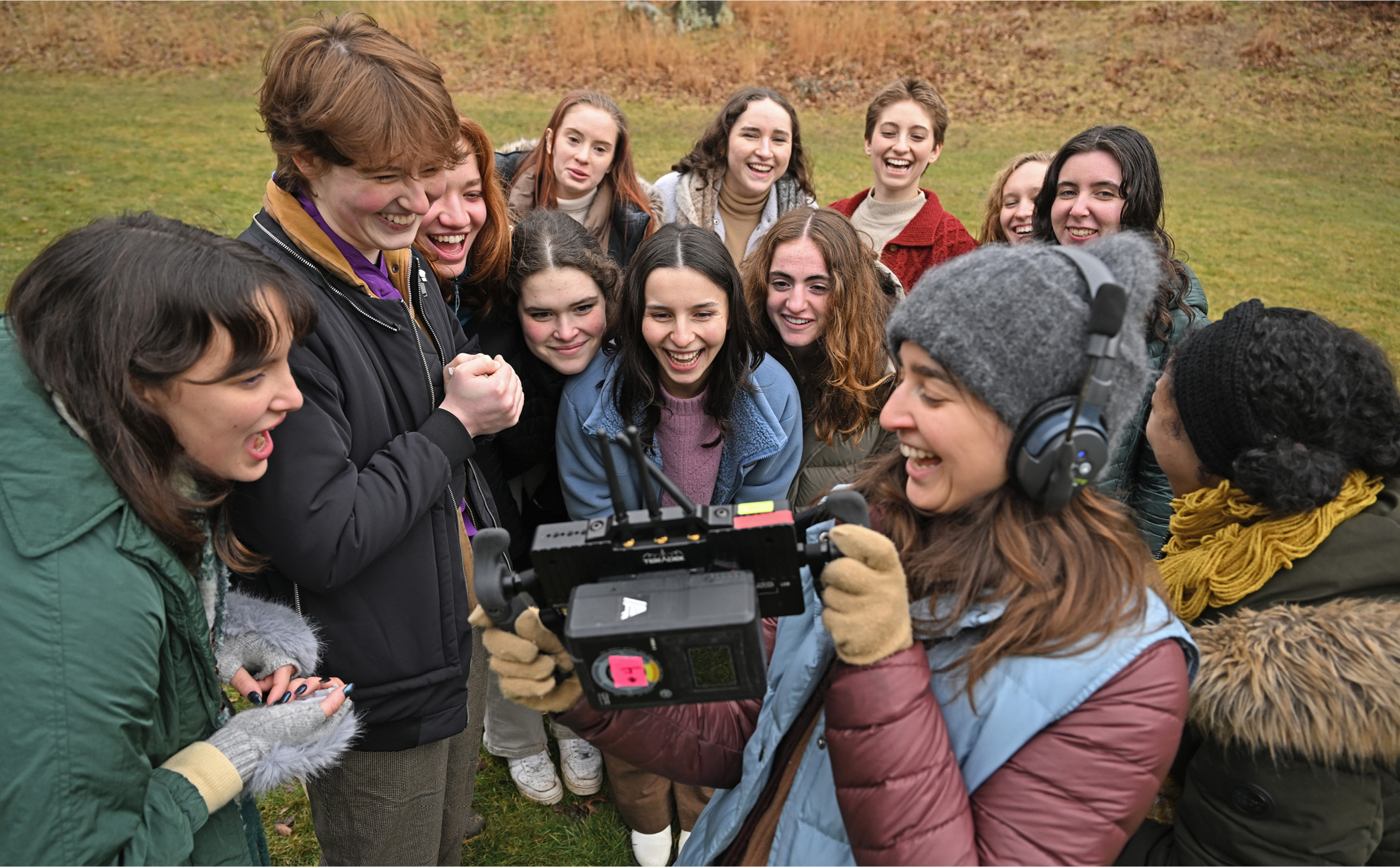 Dance students watch a video monitor of their performance in the Arboretum.