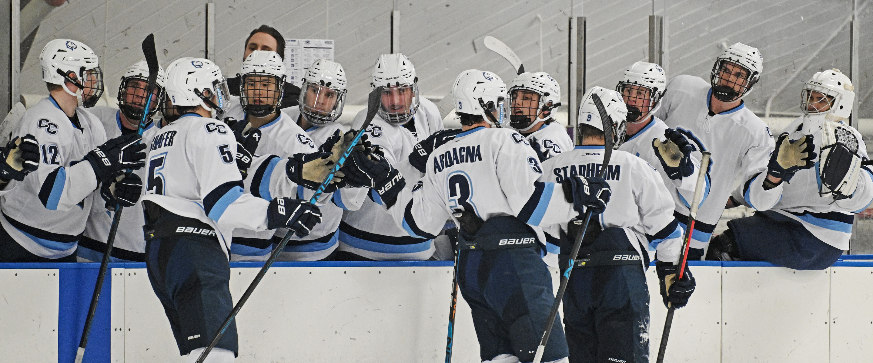 Connecticut College men’s hockey teammates congratulate players coming off the ice at Dayton Arena.