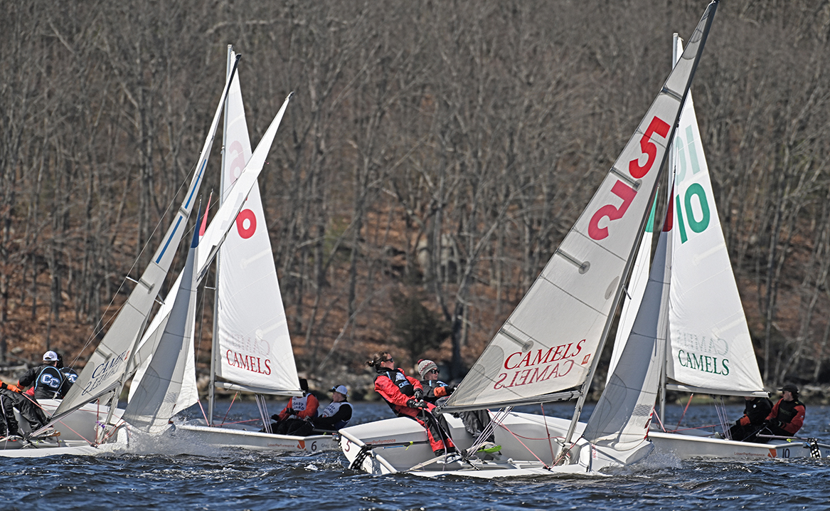 group of sailboats turn around a mark during race