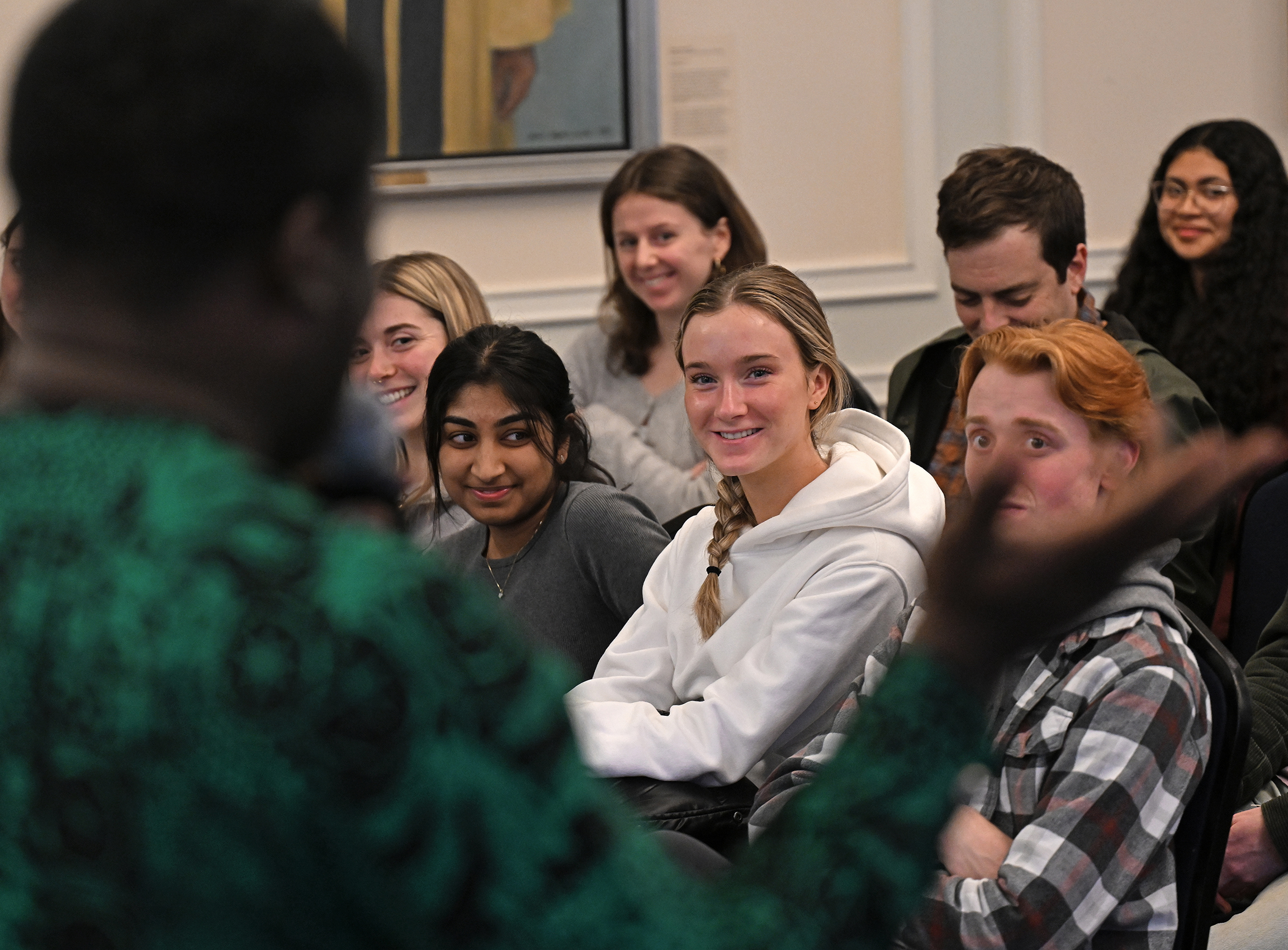 students smile as they listen to speaker