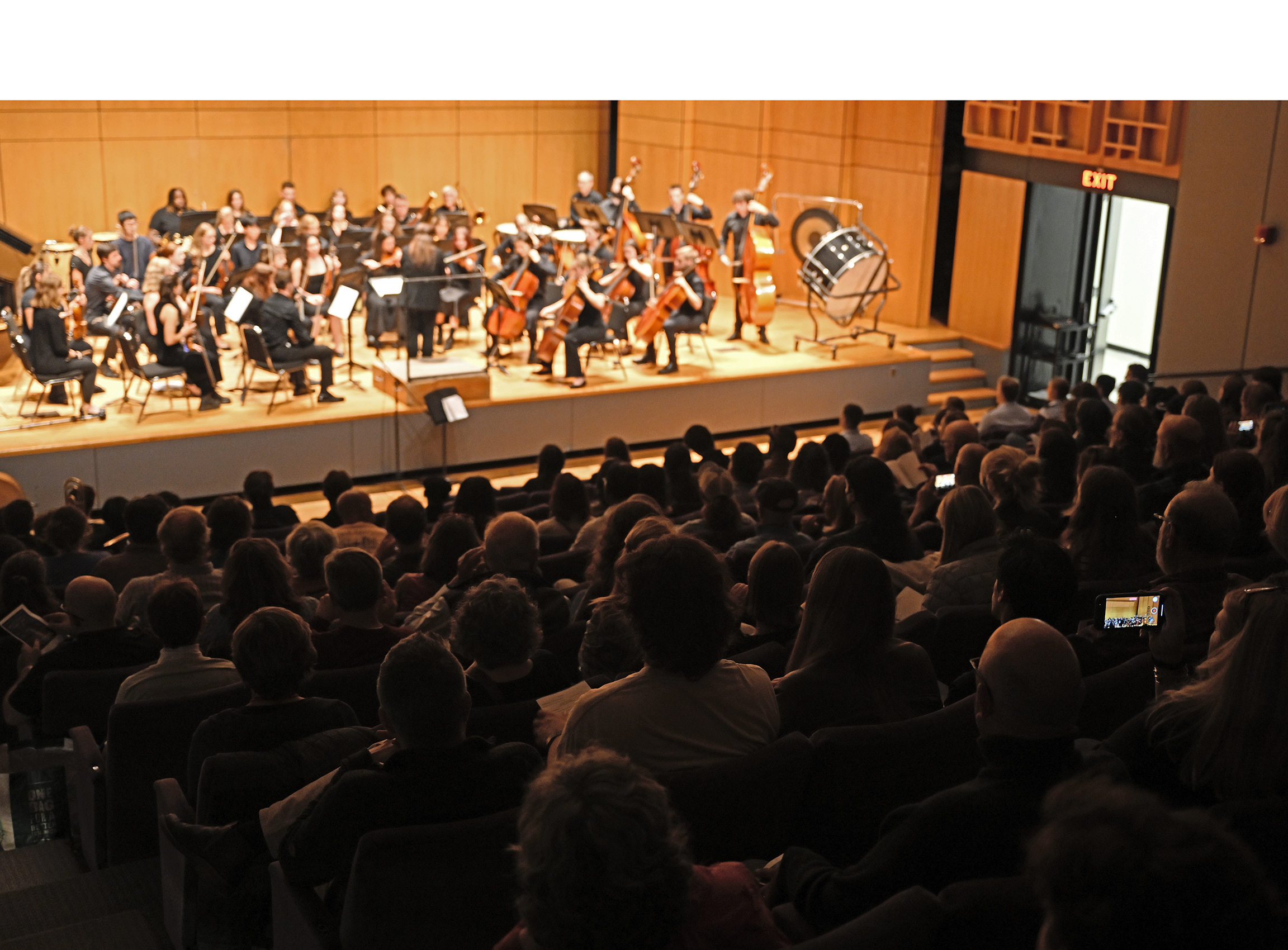 A student orchestra takes the stage to a packed house.