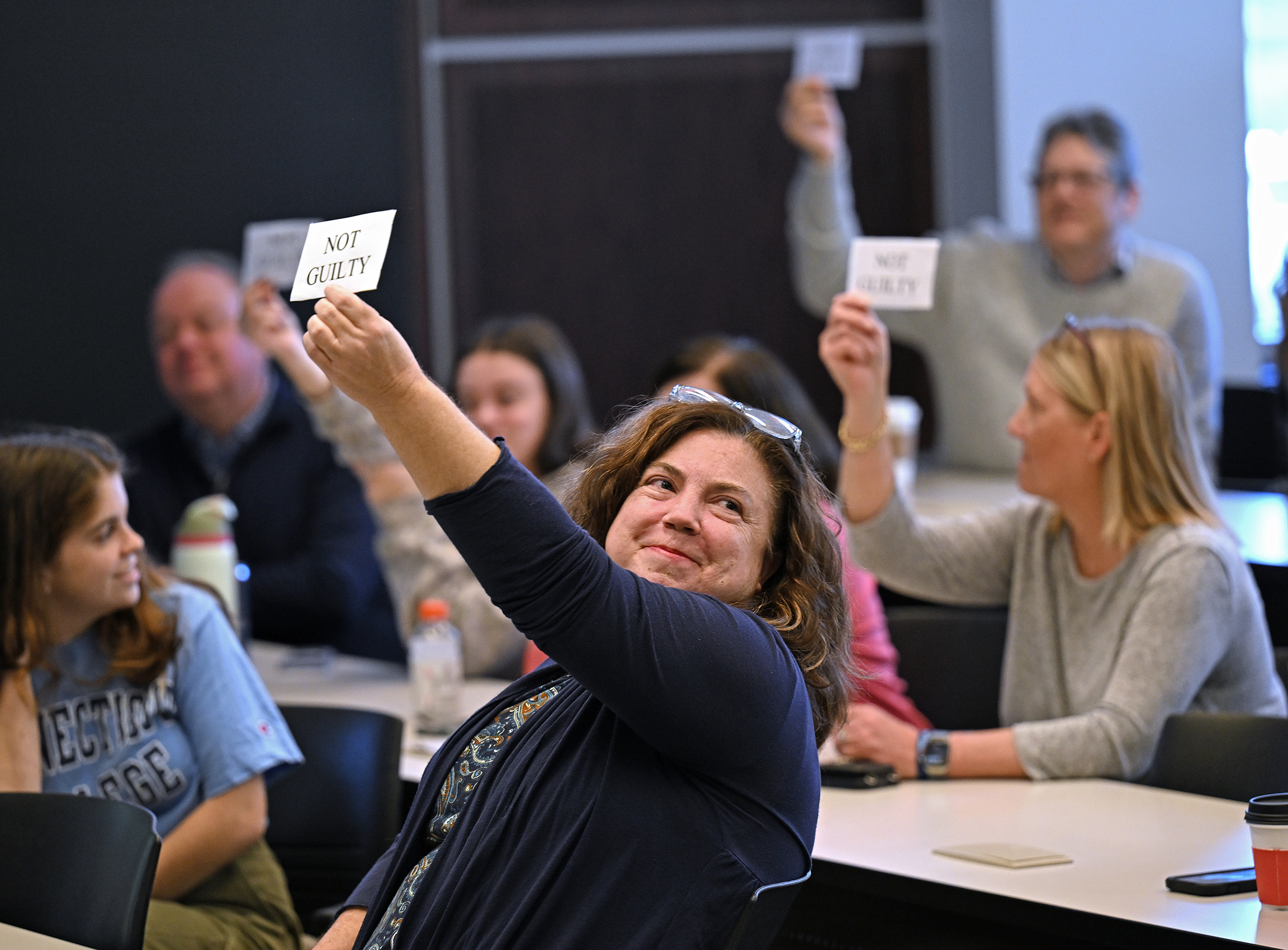 Audience at a mock trial demonstration hold up their jury votes.
