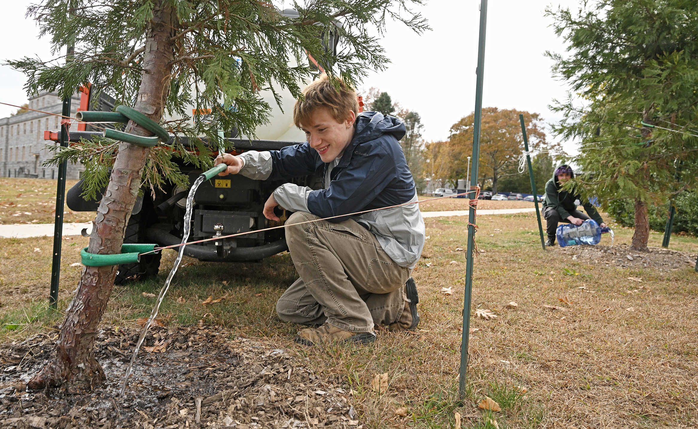 Students water young trees.