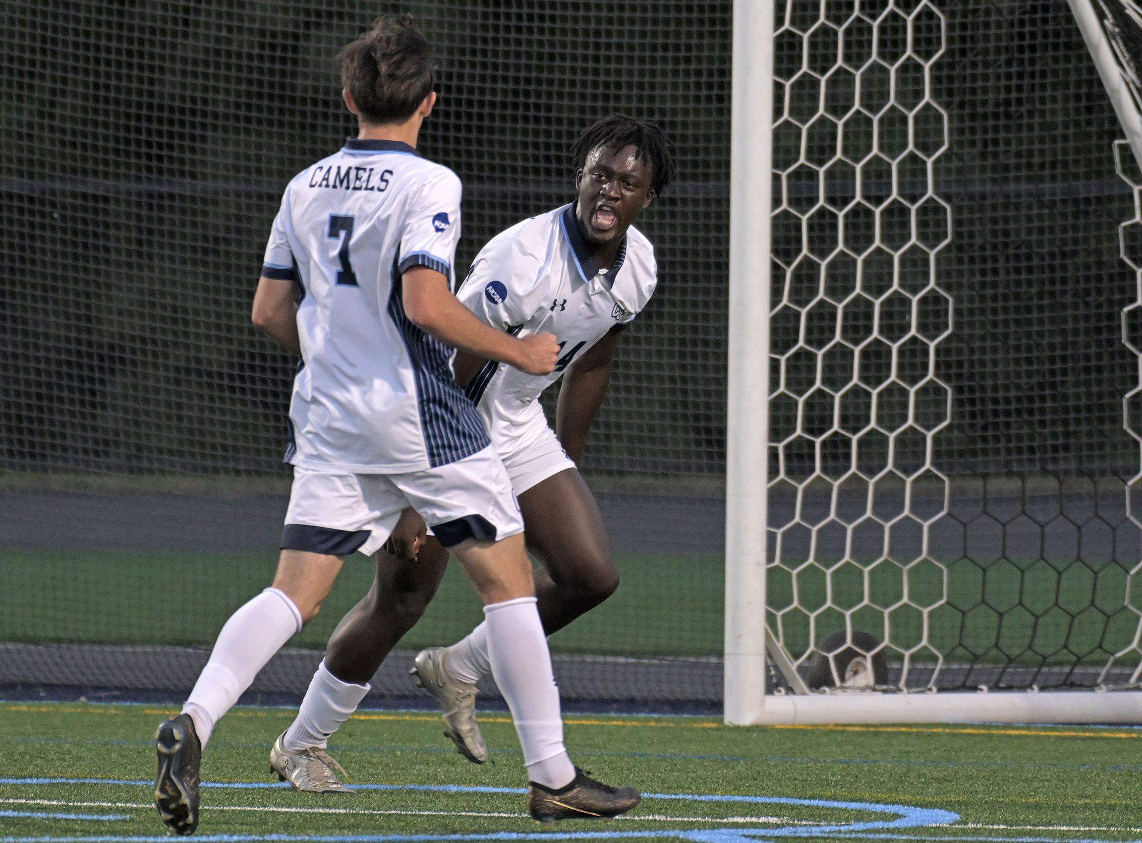 Two soccer players celebrate a goal
