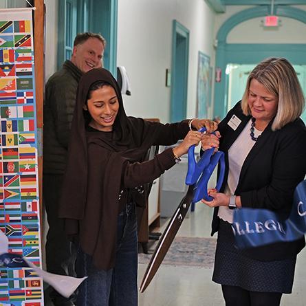 Students help President Andrea Chapdelaine cut the ribbon to officially open the International Student Lounge.