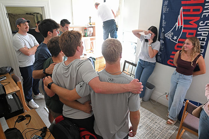 New roommates pose for a photo in their dorm room.
