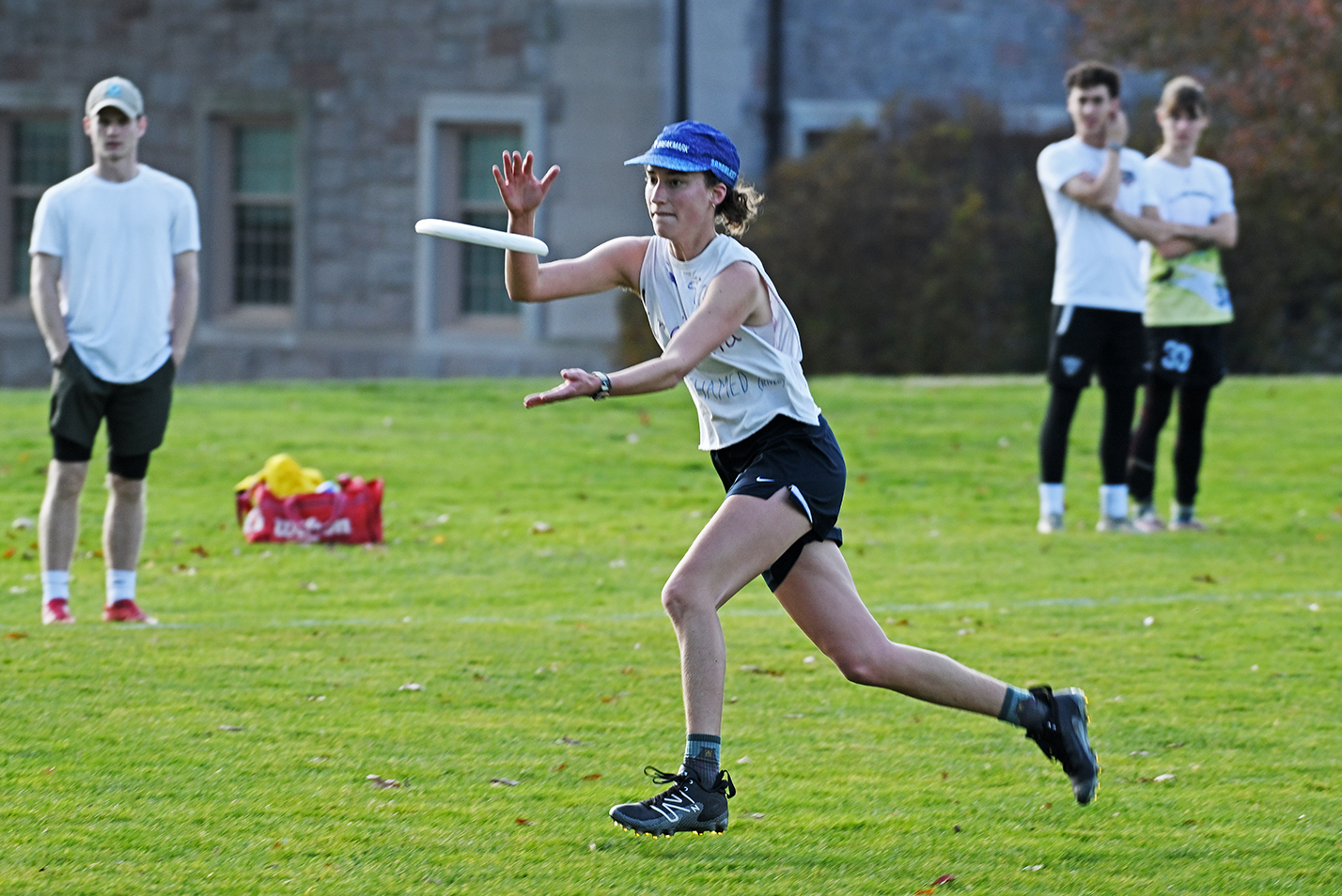A college ultimate disc player races to catch a flying disc.