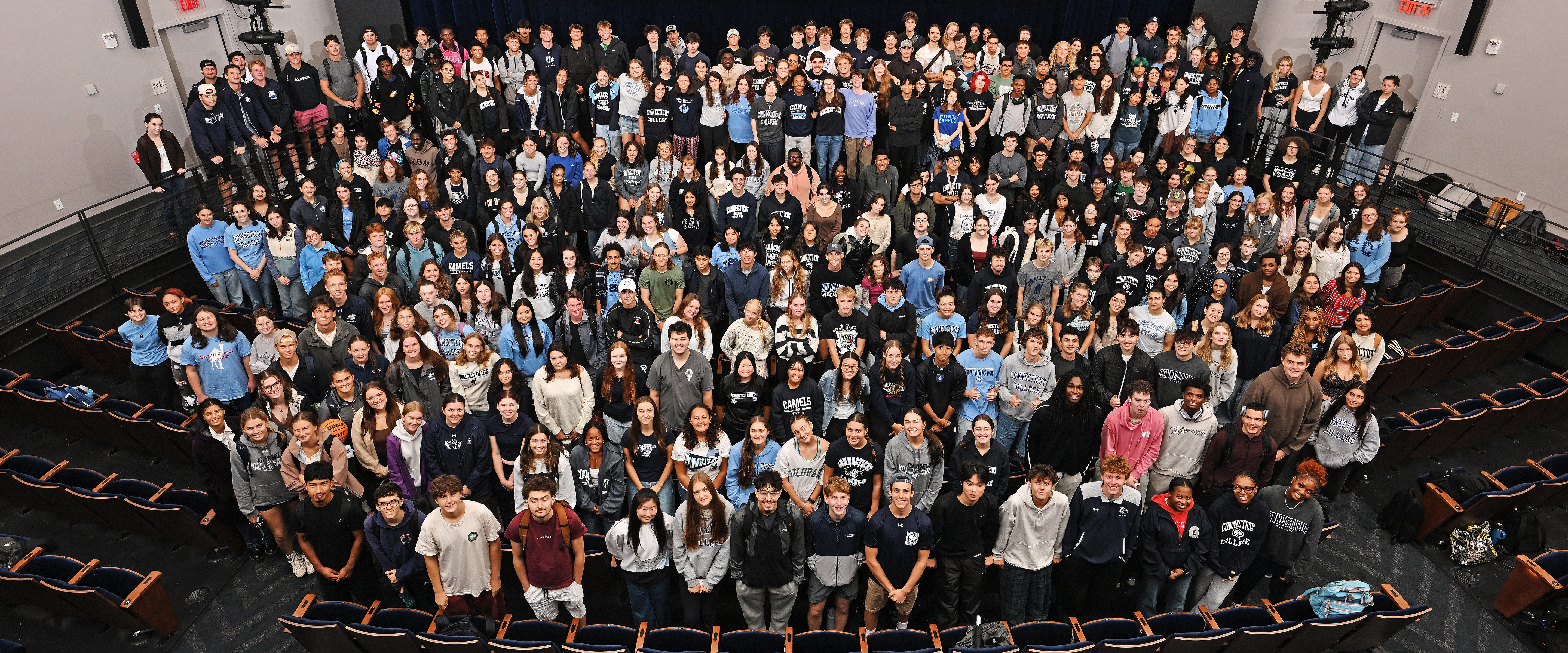 A large group photo of a college class year from overhead in an audotorium.