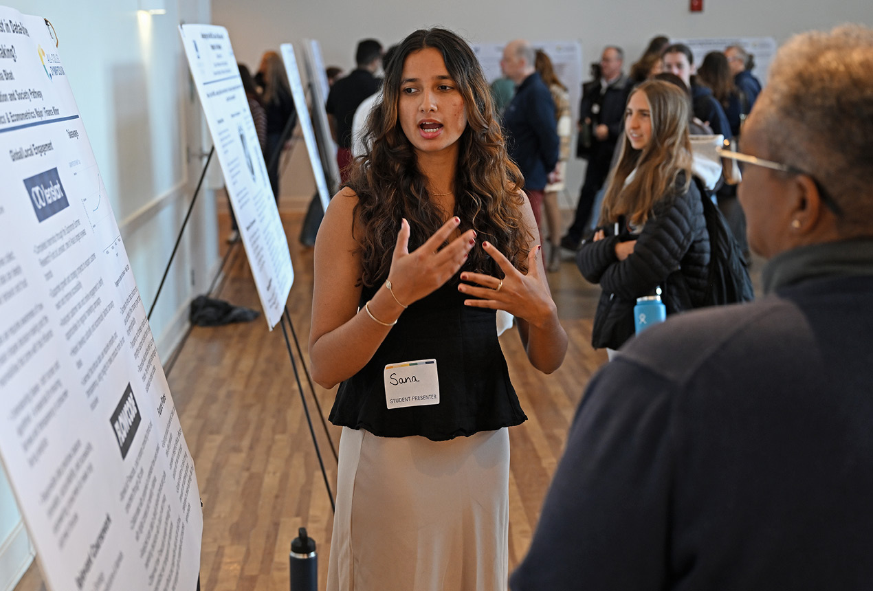 A student presents her poster at the All College Symposium