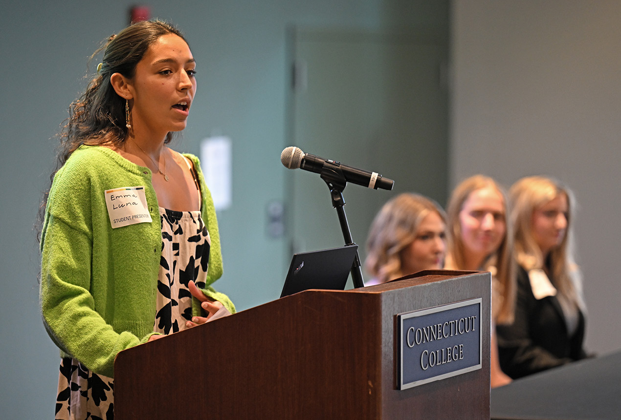 A student stands at the podium at the All College Symposium