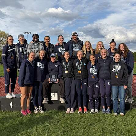 Members of the Women's Track and Field team with their coaches after winning the DIII New England championships