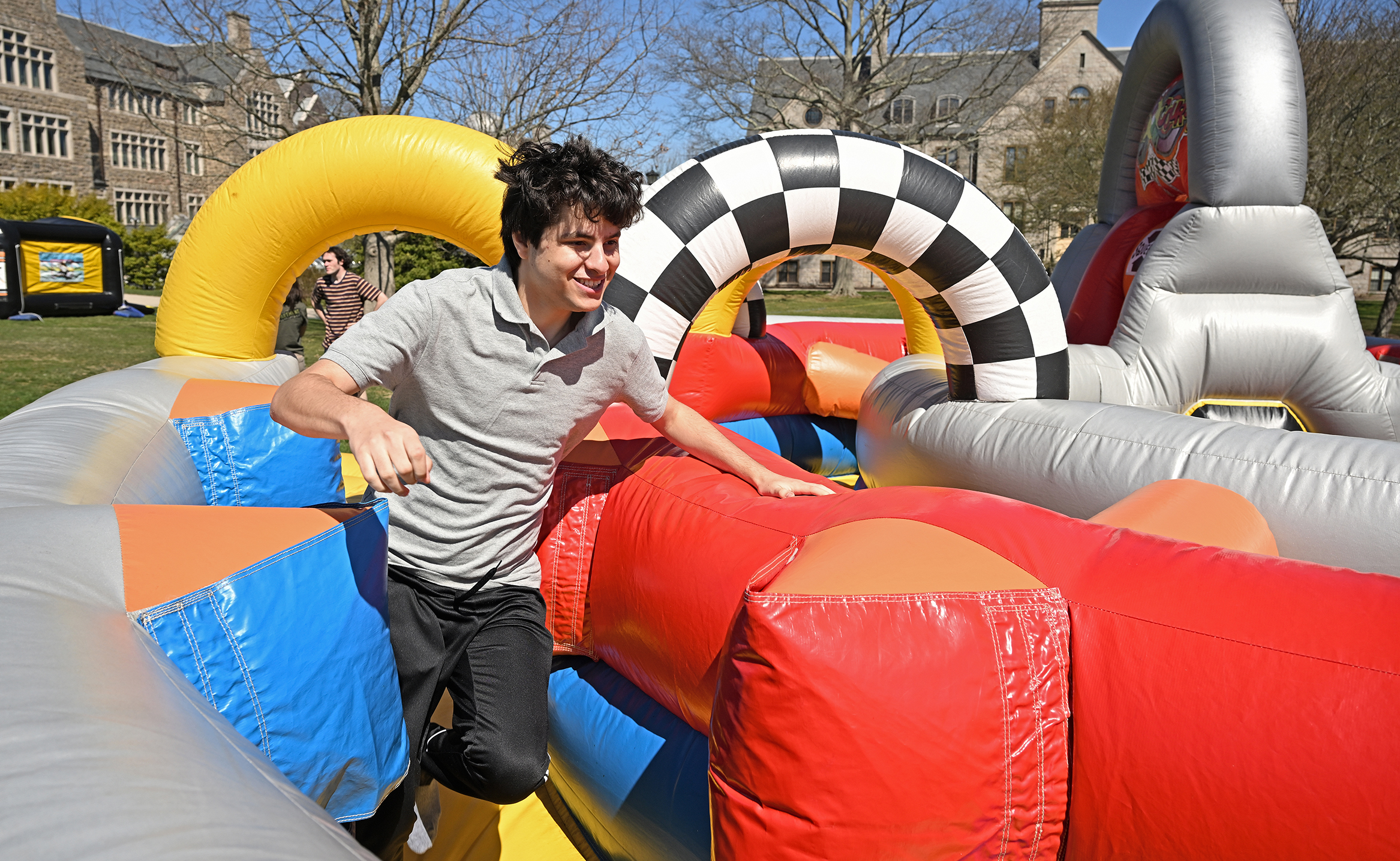 A college student races through a giant inflatable obstacle course.