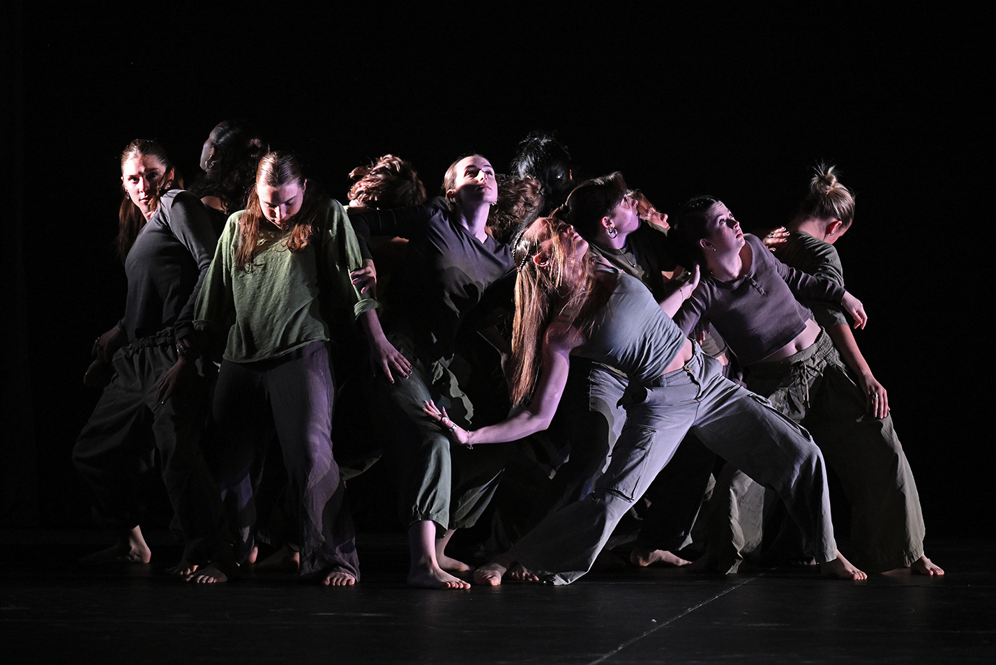 Student dancers perform a modern dance piece on stage.