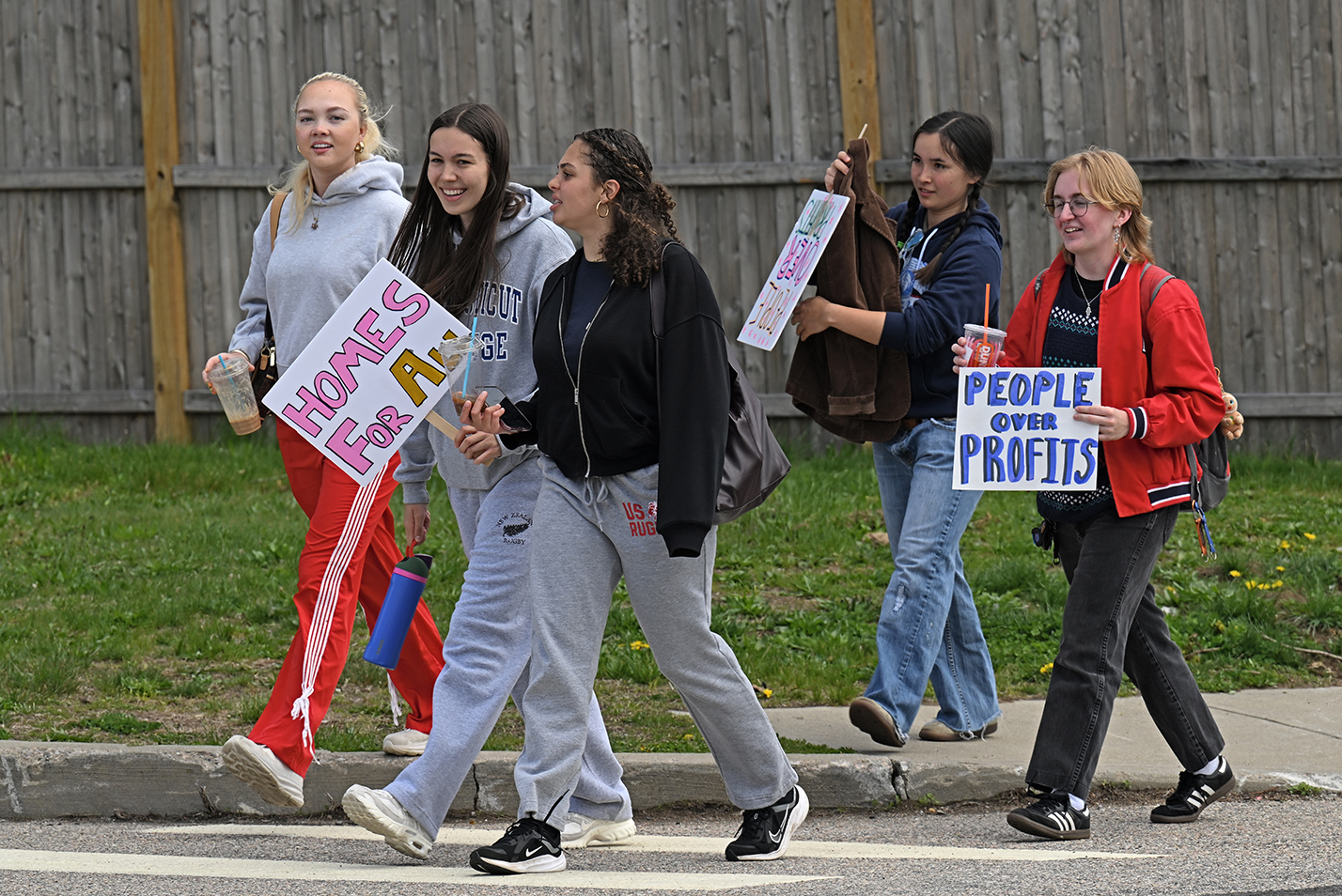 College students carrying signs that say 
