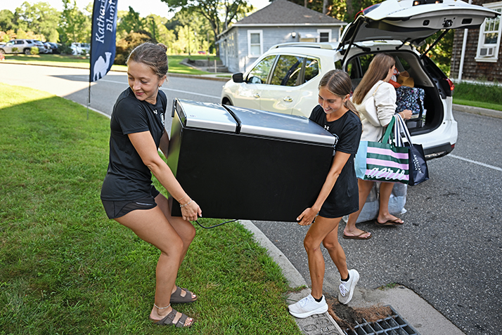 Students move a refrigerator toward a dorm.