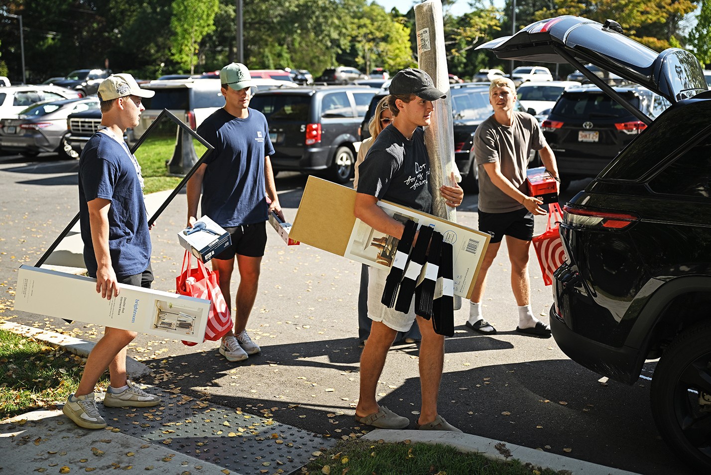 College students unload their cars to move into their residence halls on a sunny summer morning.
