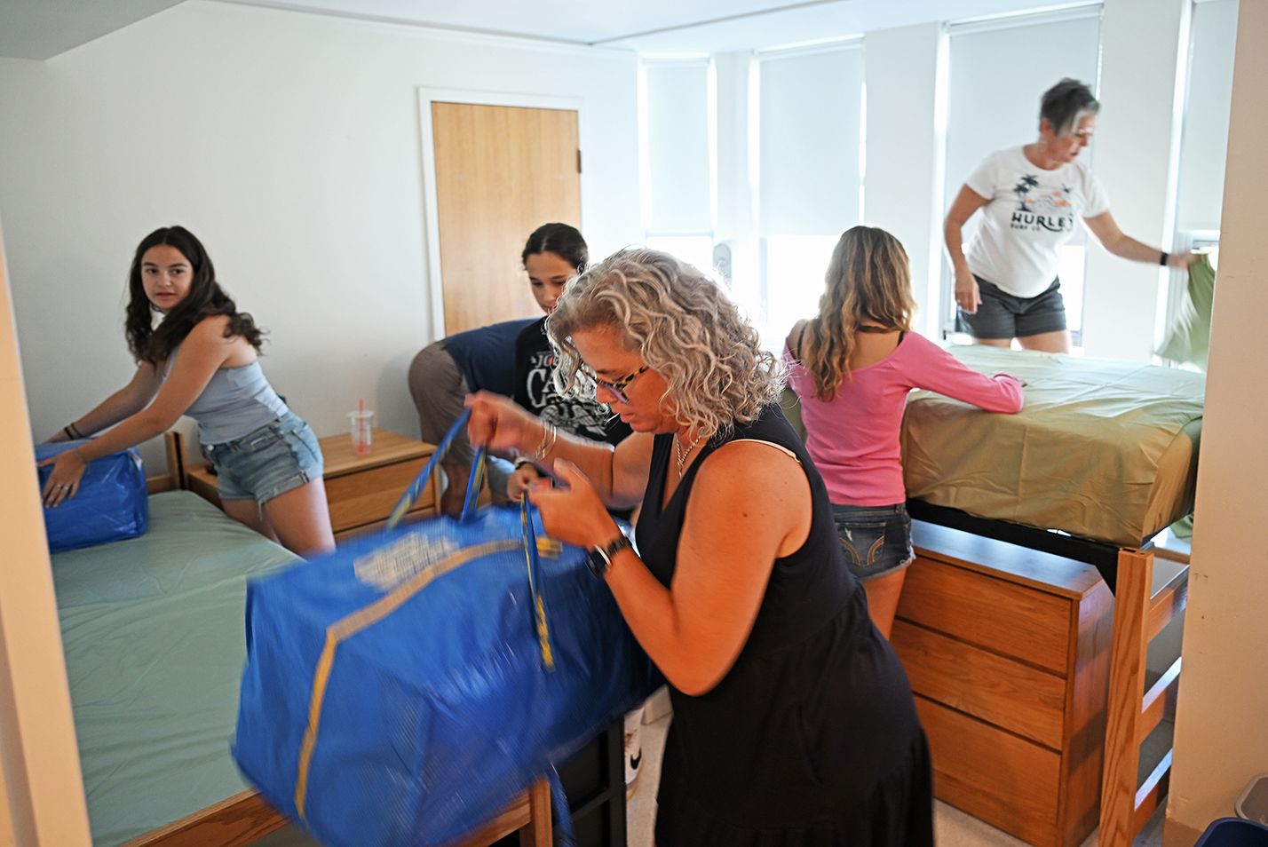 College students get help from family members setting up a dorm room.