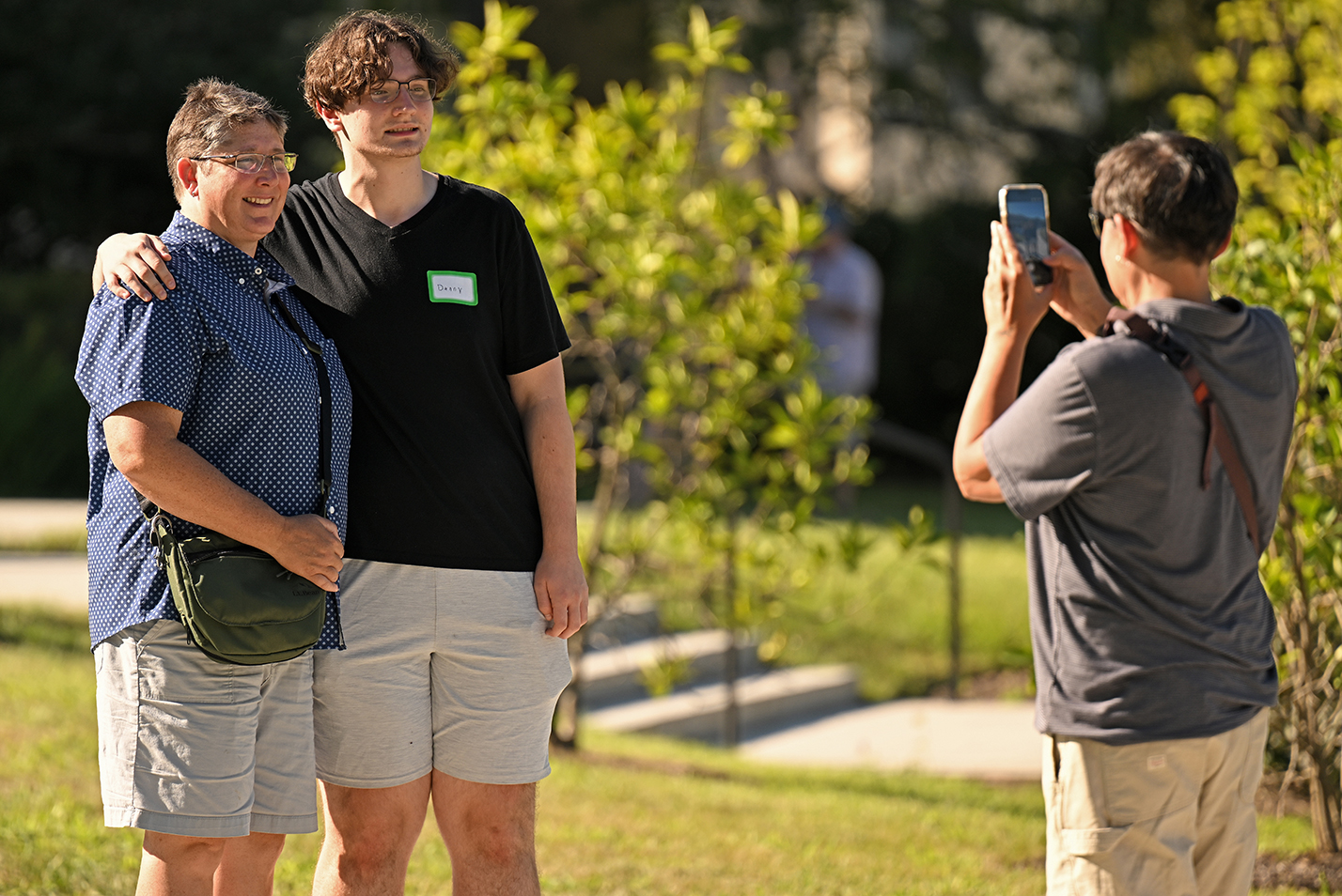 a first-year college student posses for a photo with a parent on move-in day.