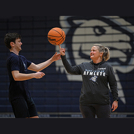RJ Casey '26 teaches President Andrea Chapdelaine how to spin a basketball on her finger.