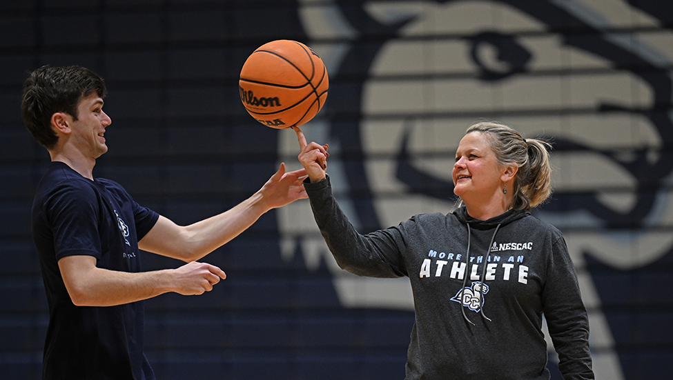 RJ Casey '26 teaches President Andrea Chapdelaine how to spin a basketball on her finger.