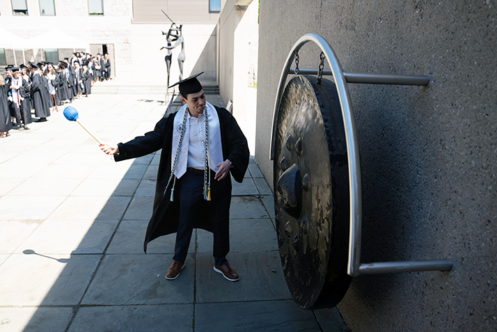 A graduate rings the gong on Commencement day.