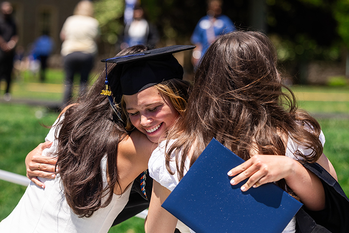 A graduate hugs her supporters.
