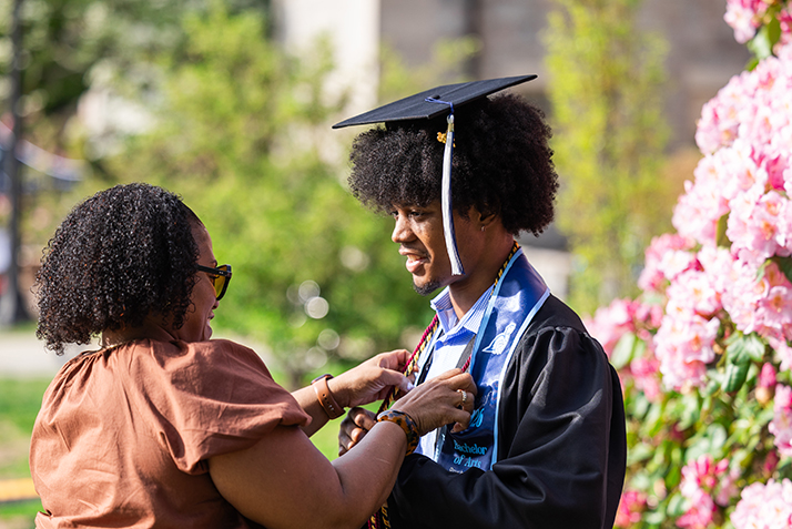 A mother helps her son with his stolls before the ceremony.