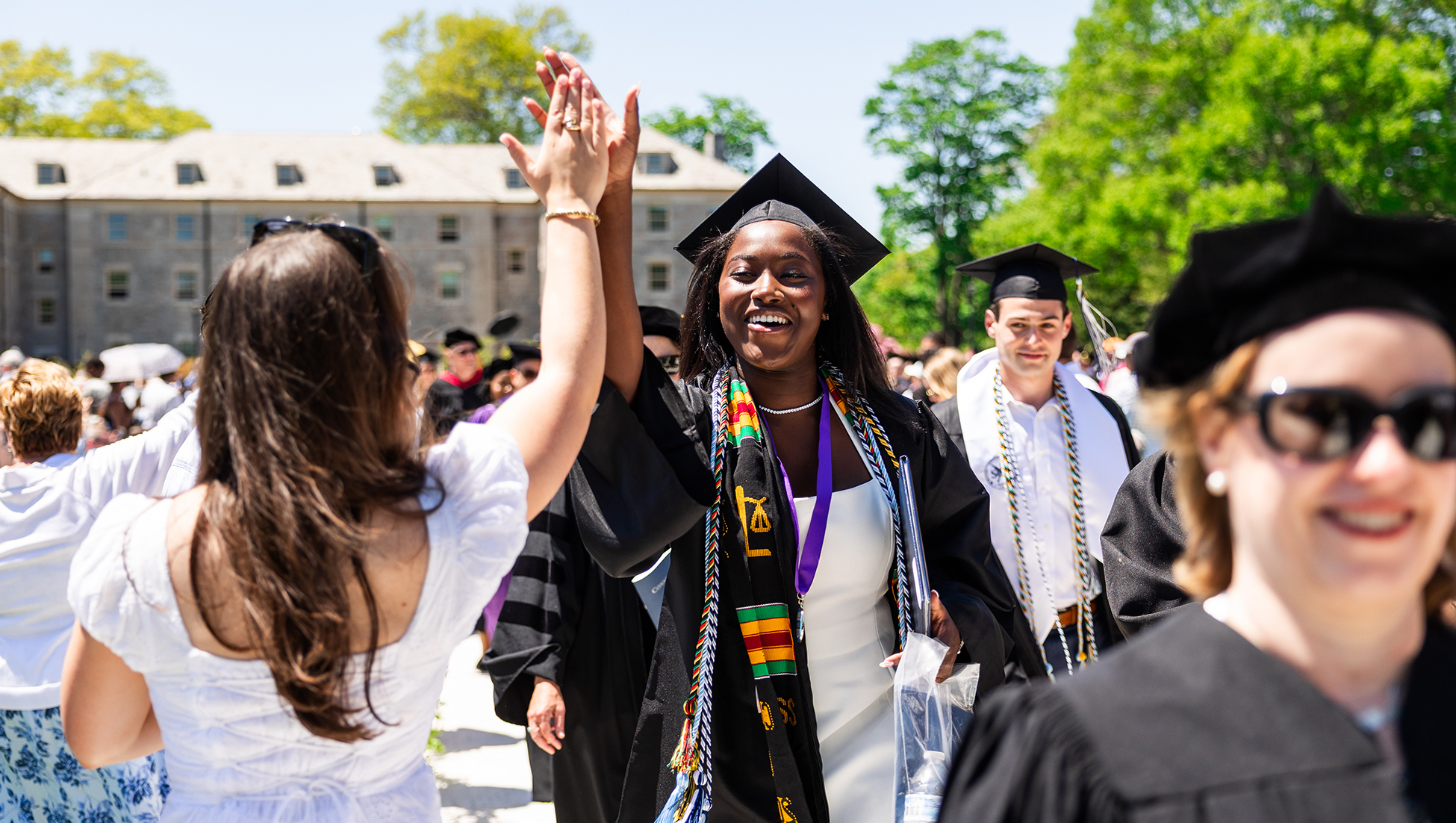 Student speaker Zoe Watts high-fives a member of the laurel chain during Commencement.