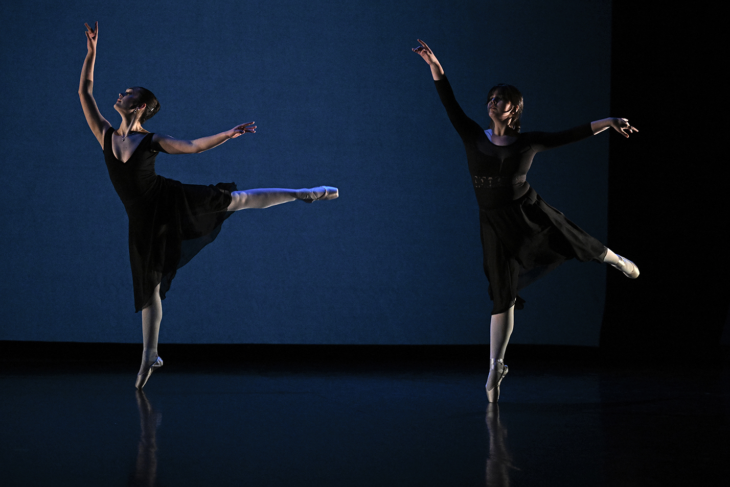 Two student dancers perform a ballet number in a college dance studio.