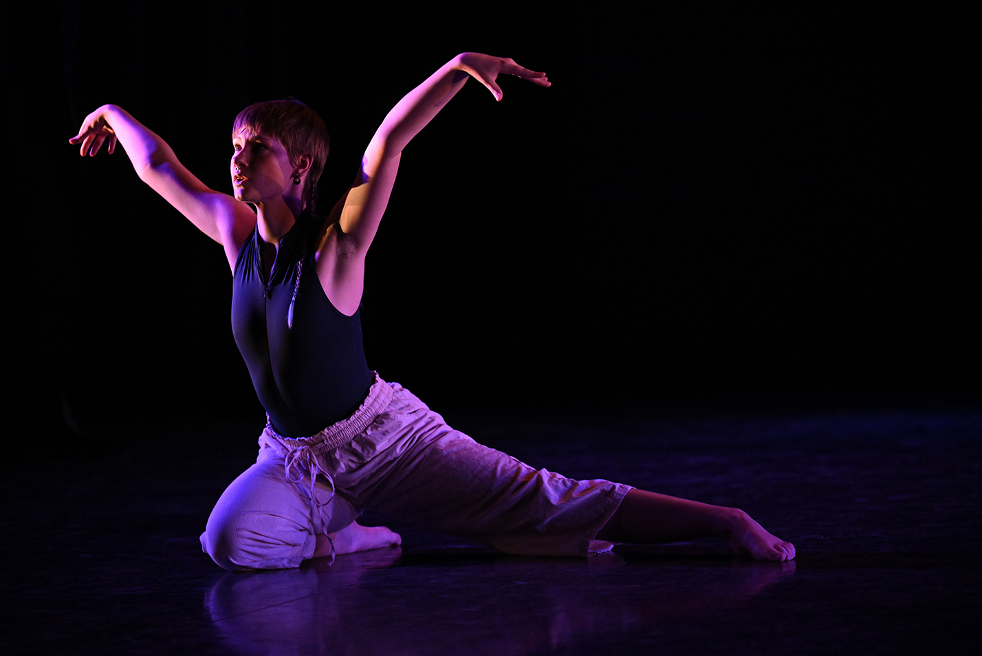 A lone student dancer performs in a college dance studio.