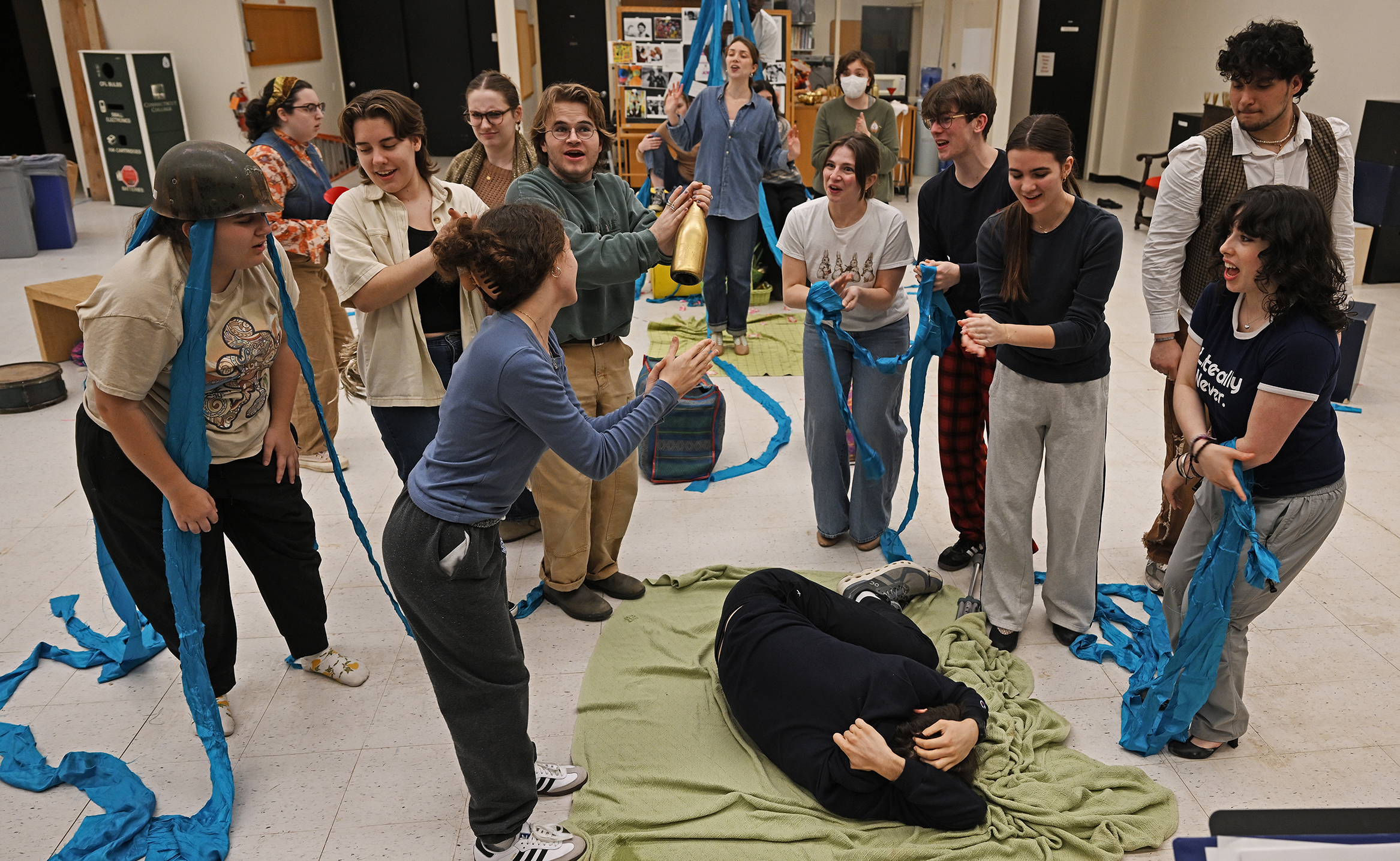A group of college student actors gather in a rehearsal space to go through a musical theater scene.