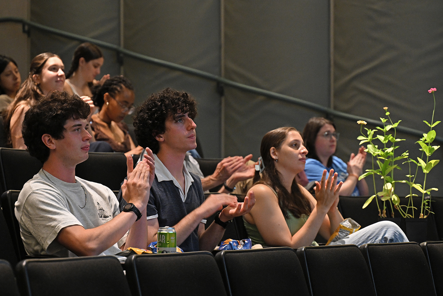 College students seated in an auditorium applaud.
