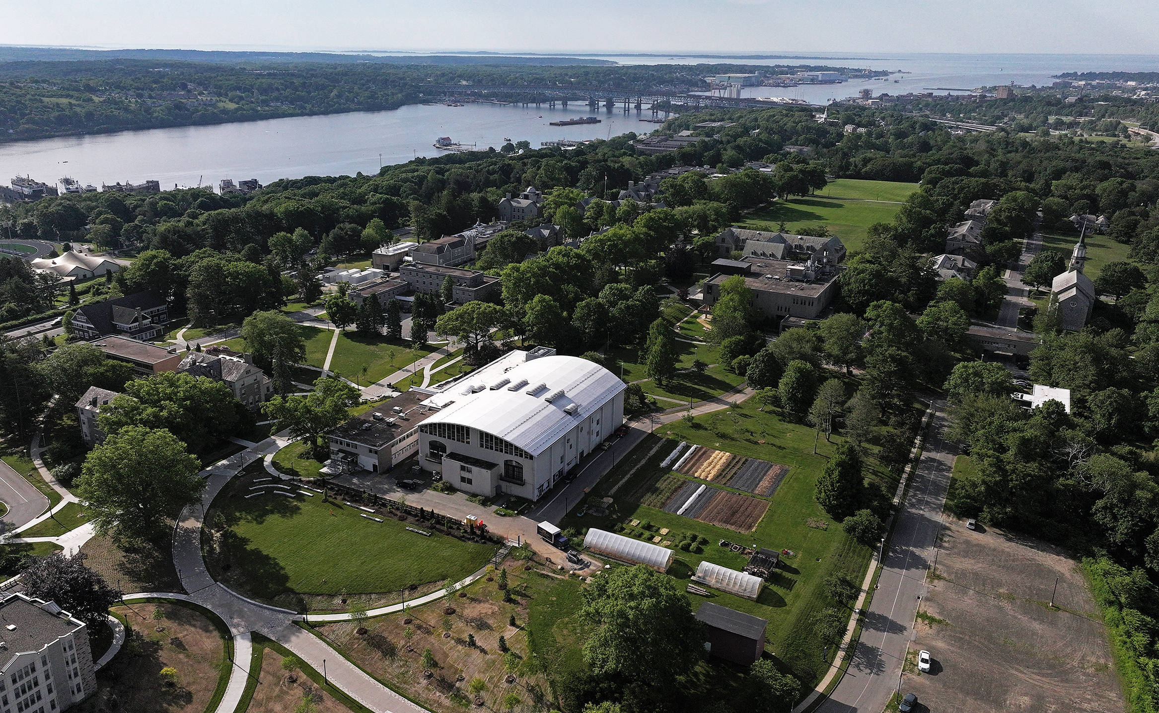 Aerial view of a college campus with a river and ocean in the distance.