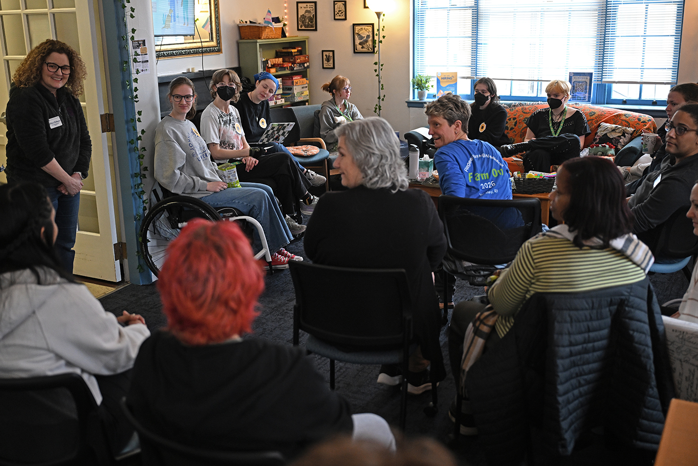 A crowd of college students, staff, and faculty gather in a community space for a discussion.