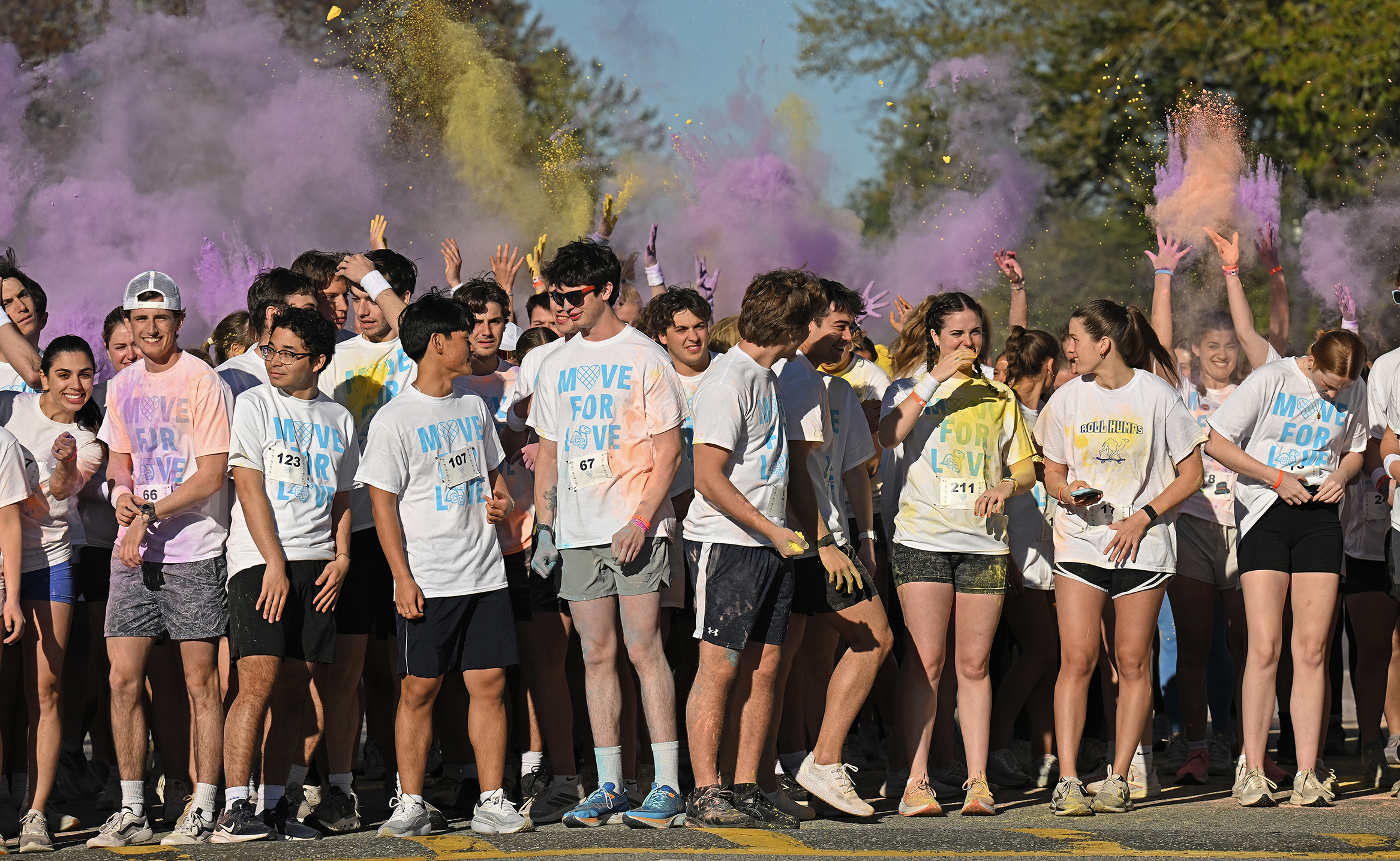 A crowd of college students in white t-shirts reading 