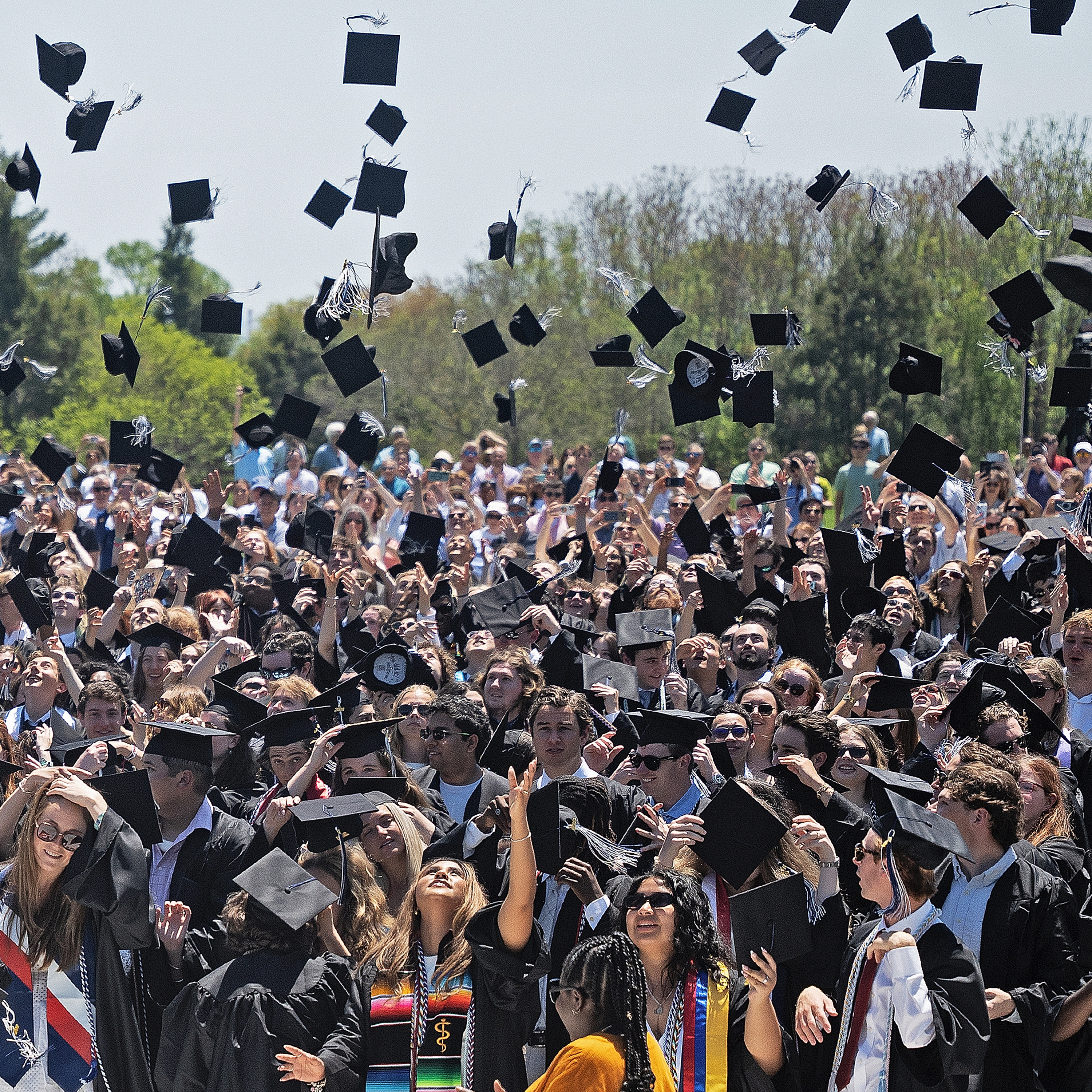 Graduates toss their caps in the air at the conclusion of commencement exercises.