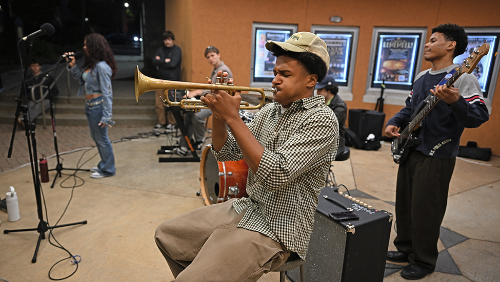 Students perform during the We Live Here opening event.