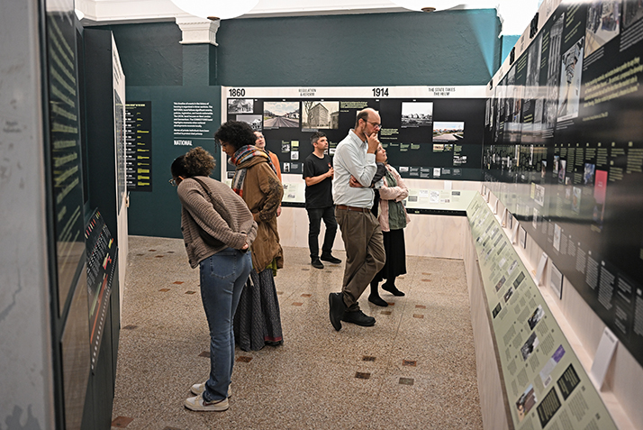 Visitors peruse the We Live Here exhibition