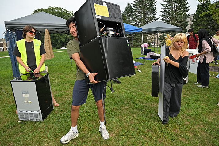 Students carry their purchases from the Give N Go yardsale.