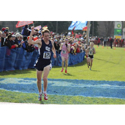 Michael LeDuc '14 raises his hand in victory as he crosses the finish line at the 2013 NCAA Division III Men’s Cross Country Championship. Photo by Russell Kramer