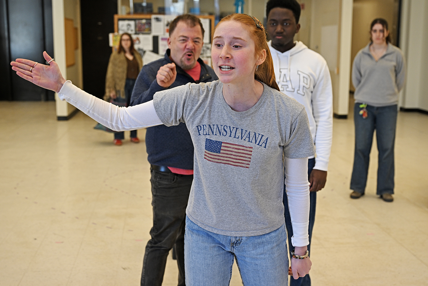 An actor gestures and sings during a musical play rehearsal.