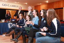Members of the Connecticut College women's volleyball react as they watch the NCAA selection show with President Lee Higdon and Fran Shields, the Katherine Wenk Christoffers '45 Director of Athletics at Connecticut College.