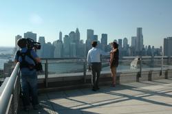 Kristina Helb '04, far right, shoots a scene for HGTV's Selling New York at a penthouse unit in Brooklyn overlooking the Manhattan skyline.